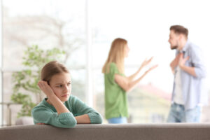 parents fighting with daughter looking distressed