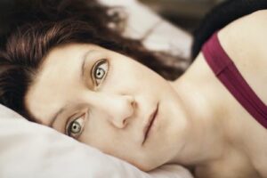 woman lying in bed deep in thought